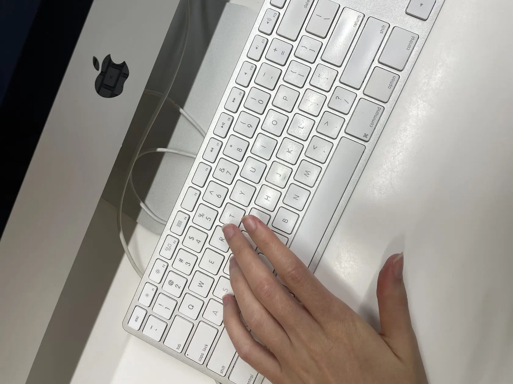 a computer with a hand on a keyboard