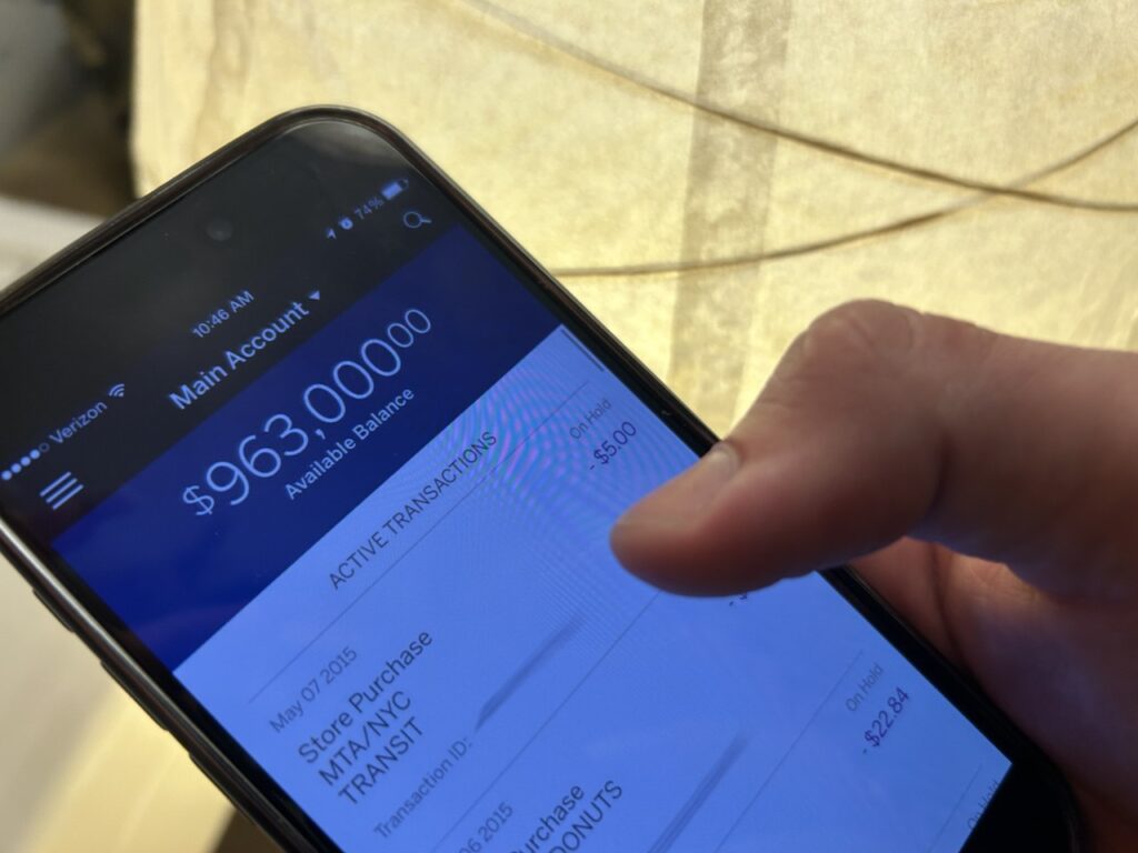 how does yelp make money shown with a person holding a phone with a bank account numbers visible